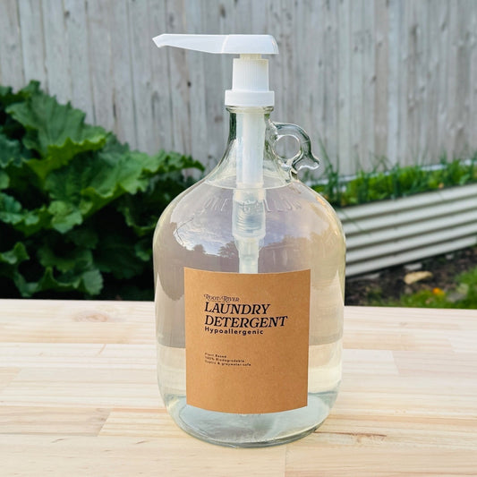 Reusable glass jug of laundry detergent on a wooden surface